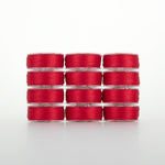 Red thread on clear plastic bobbins stacked in four rows of three, showing bright red Dream Seam Class 15 thread spools
