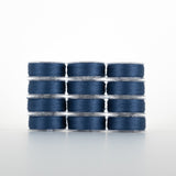 Twelve clear plastic bobbins of navy blue thread stacked in a 4x3 grid formation