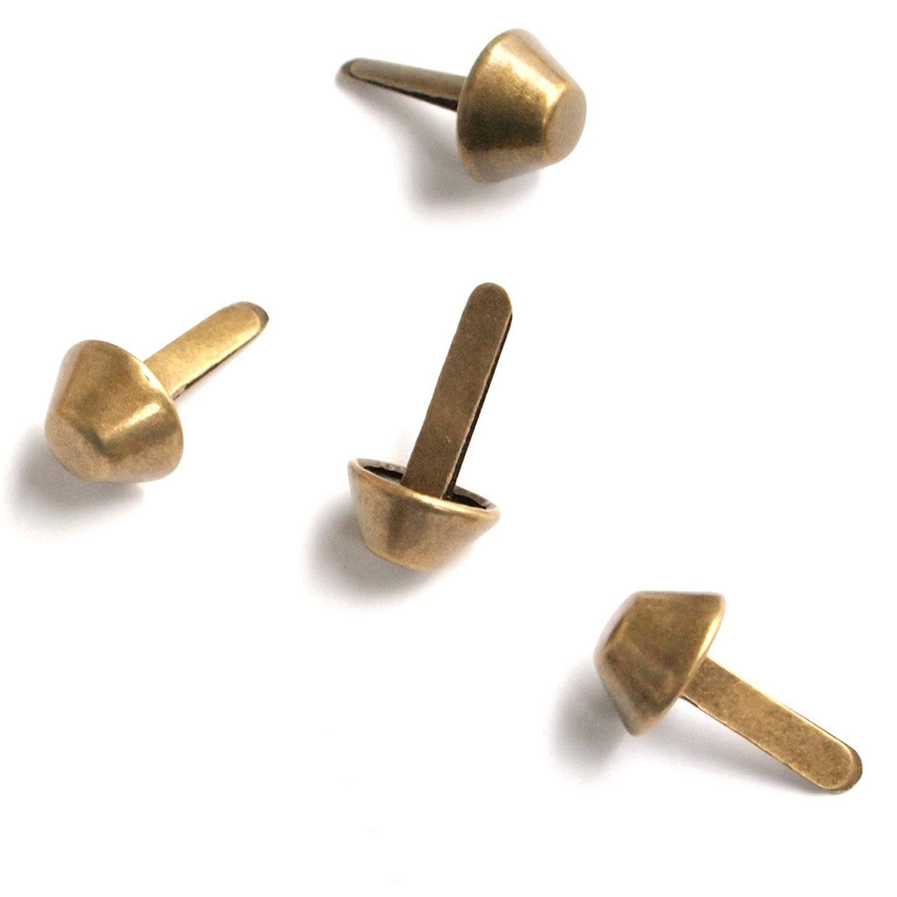 Four antique brass-colored metal bag feet with curved bucket-like heads and flat mounting stems shown from different angles.