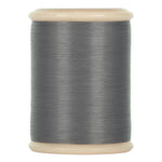 A spool of dark gray cotton hand quilting thread from YLI threads