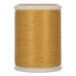 Gold quilting thread wound on white plastic spool with rounded ends