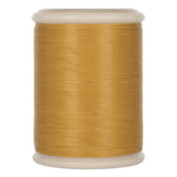 Gold quilting thread wound on white plastic spool with rounded ends