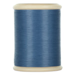 Gray blue hand quilting thread wound on white plastic spool with cream-colored ends