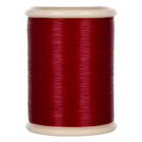 Red quilting thread wound on white plastic spool with visible thread texture and sheen