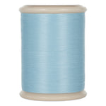 Light blue hand quilting thread wound on white plastic spool with cream colored top and bottom flanges