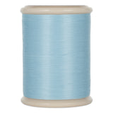 Light blue hand quilting thread wound on white plastic spool with cream colored top and bottom flanges