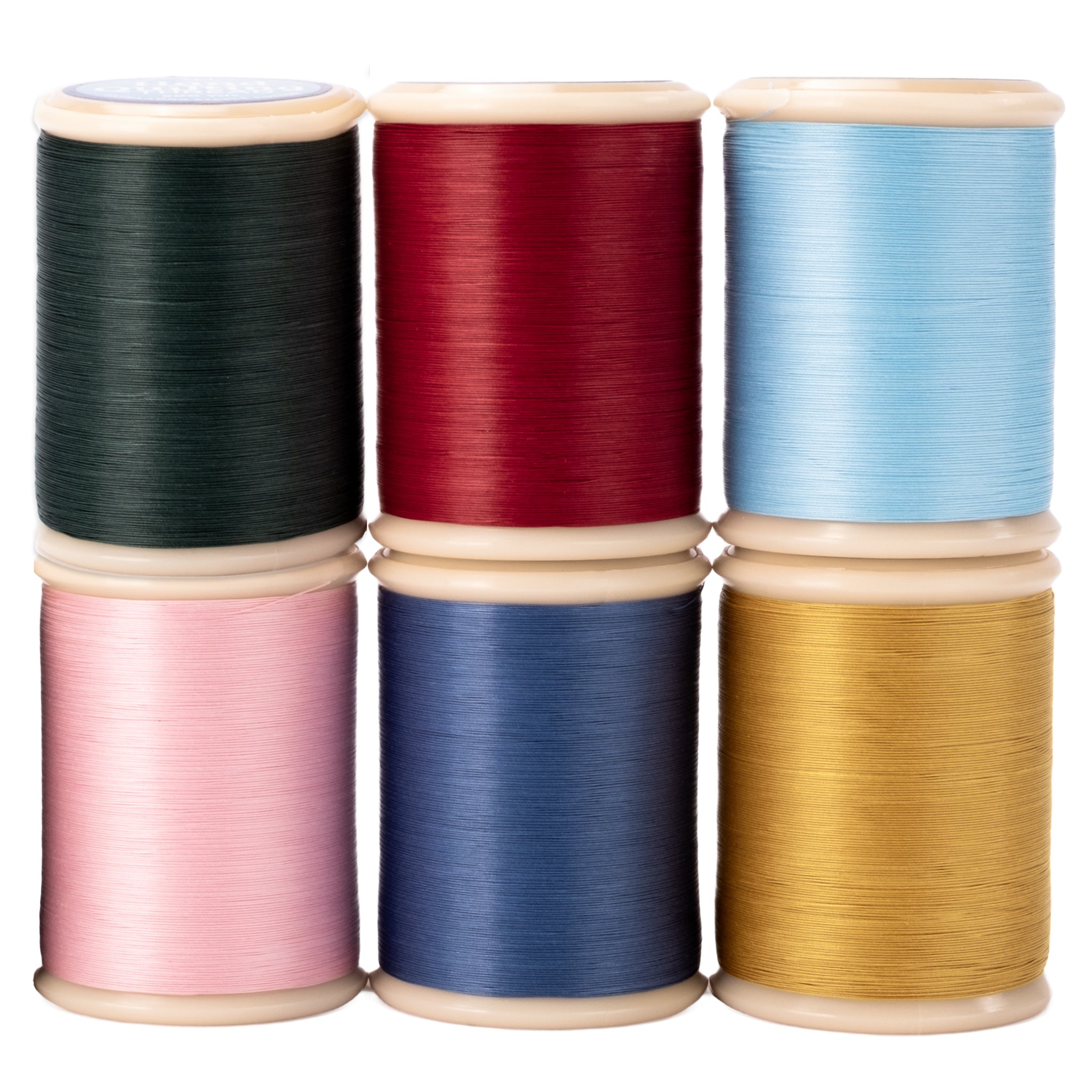 Set of colorful spools of yli hand quilting thread on a white background
