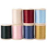 Set of colorful spools of yli hand quilting thread on a white background