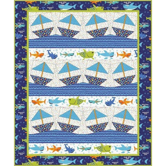 A colorful quilt pattern featuring rows of blue sailboats on water with decorative fish borders in navy, blue, and green tones.