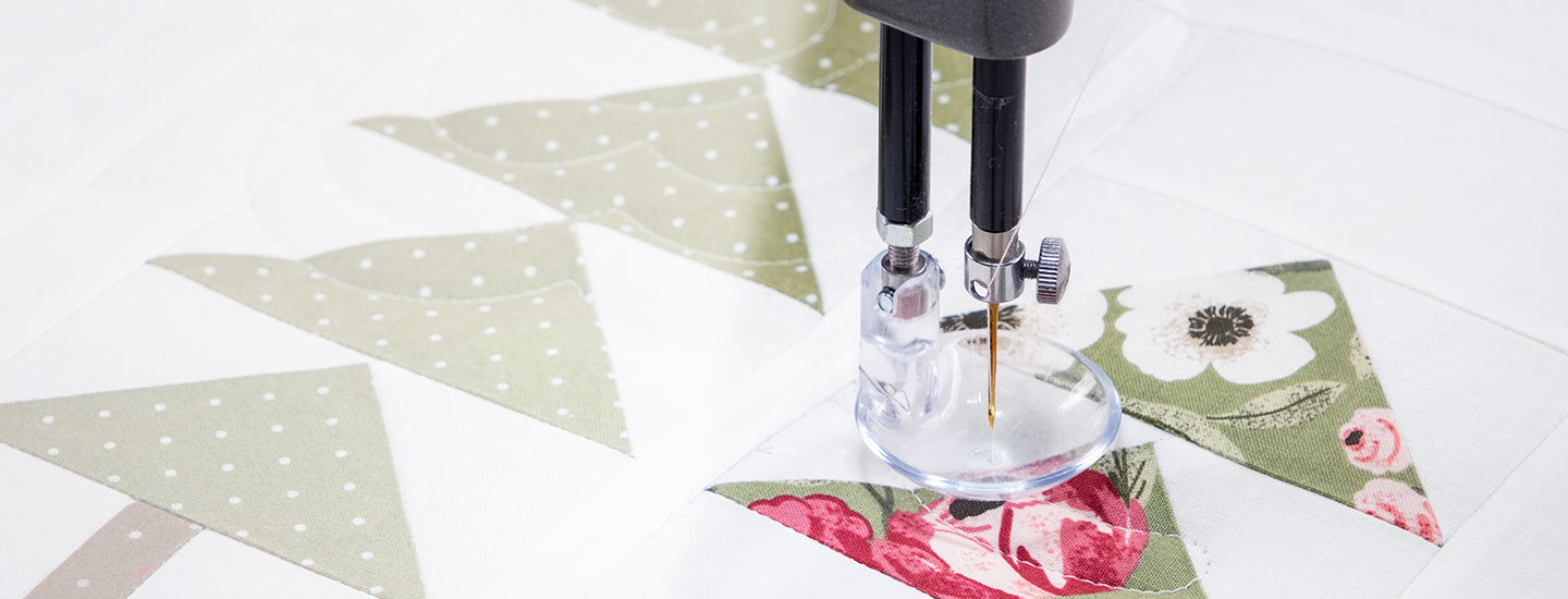 a longarm machine quilting a quilt using perfection thread with slight white opacity