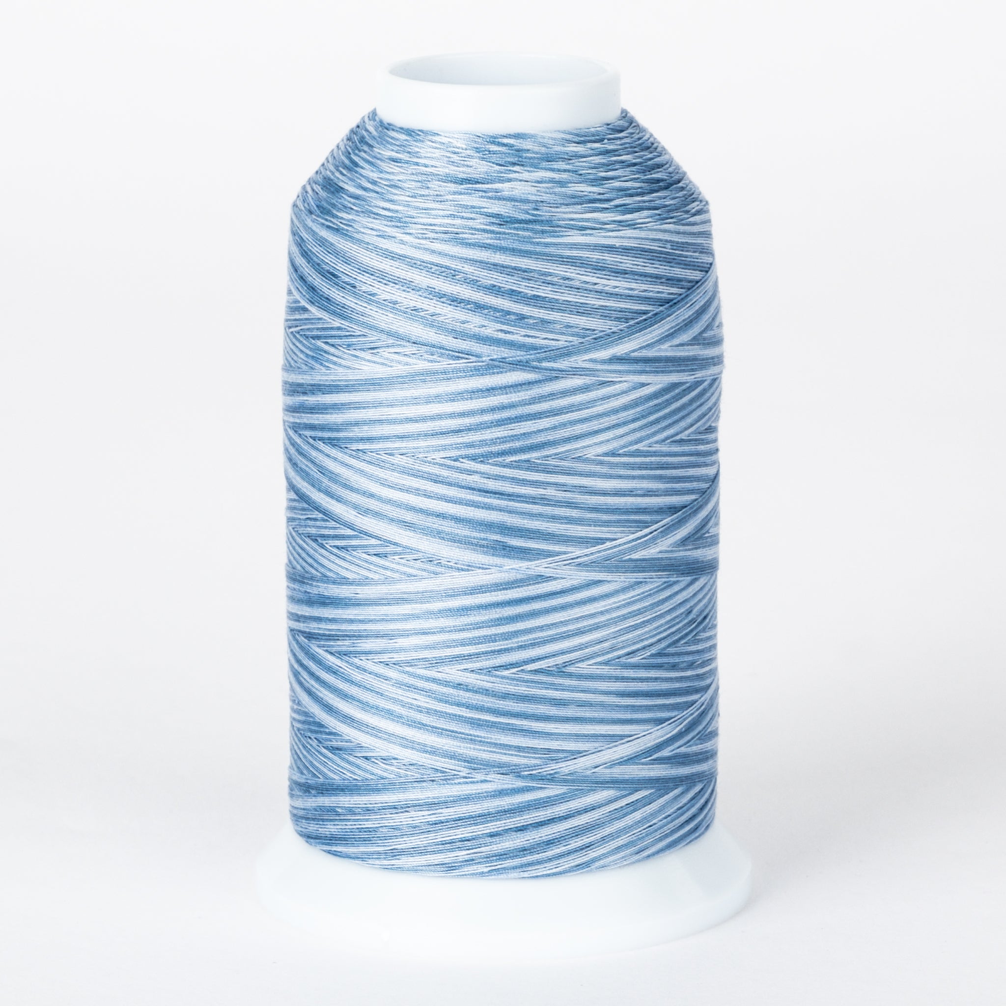 Blue and white variegated 40 wt thread on white cone spool with Surfer's Paradise multicolored pattern