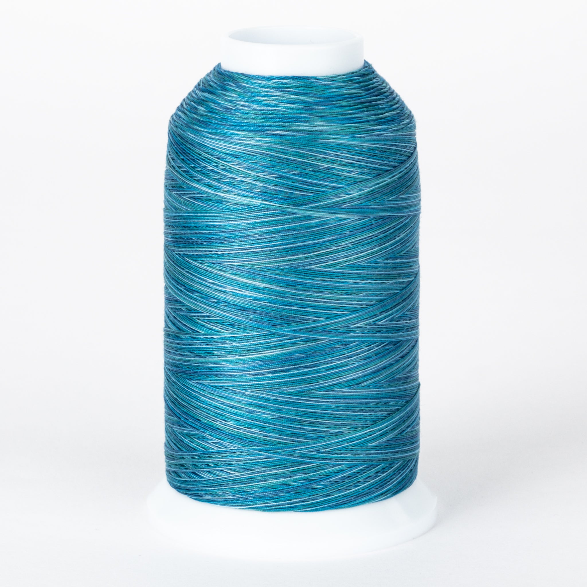 Blue variegated embroidery thread on white cone spool with multiple shades of blue and teal creating a marbled effect
