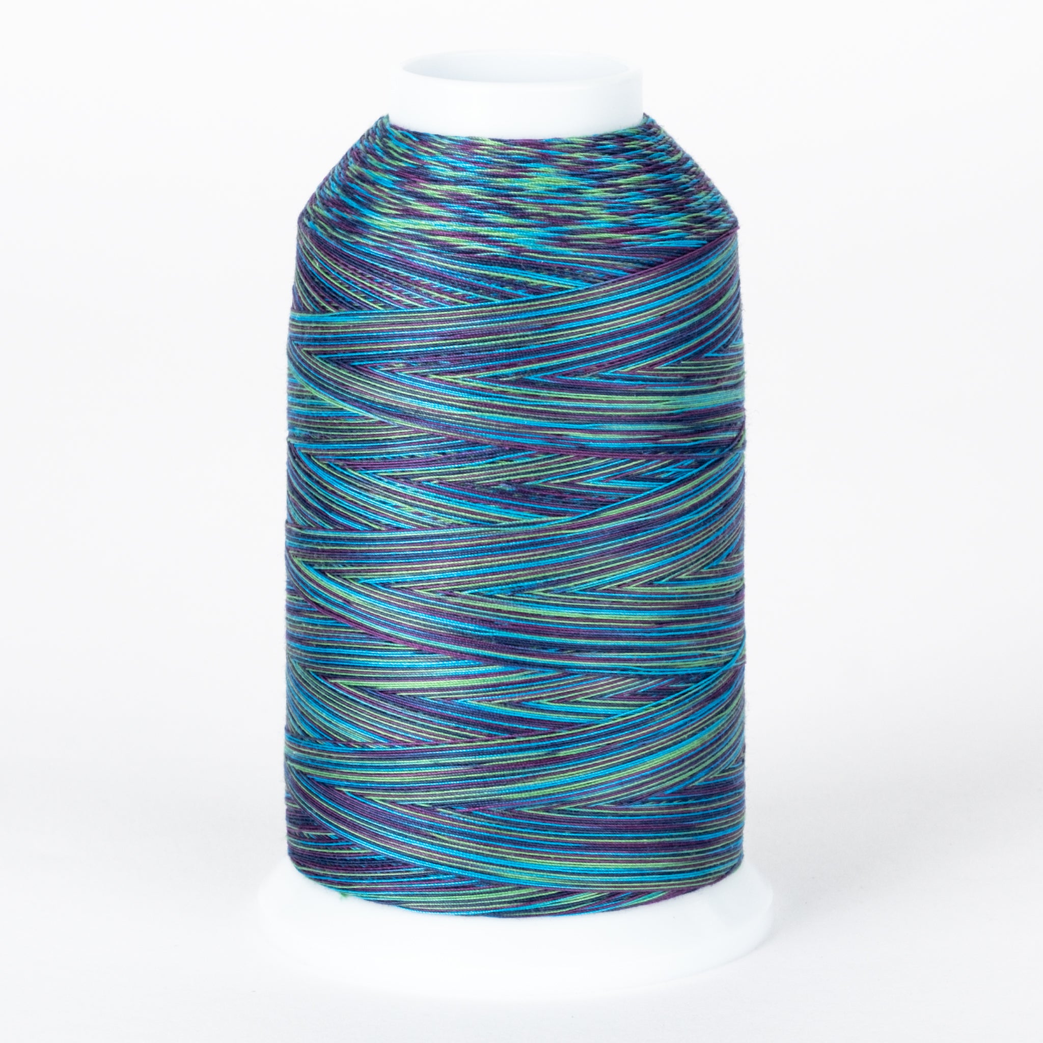 Multicolored variegated thread on white cone with blues, greens, and purples in striped pattern