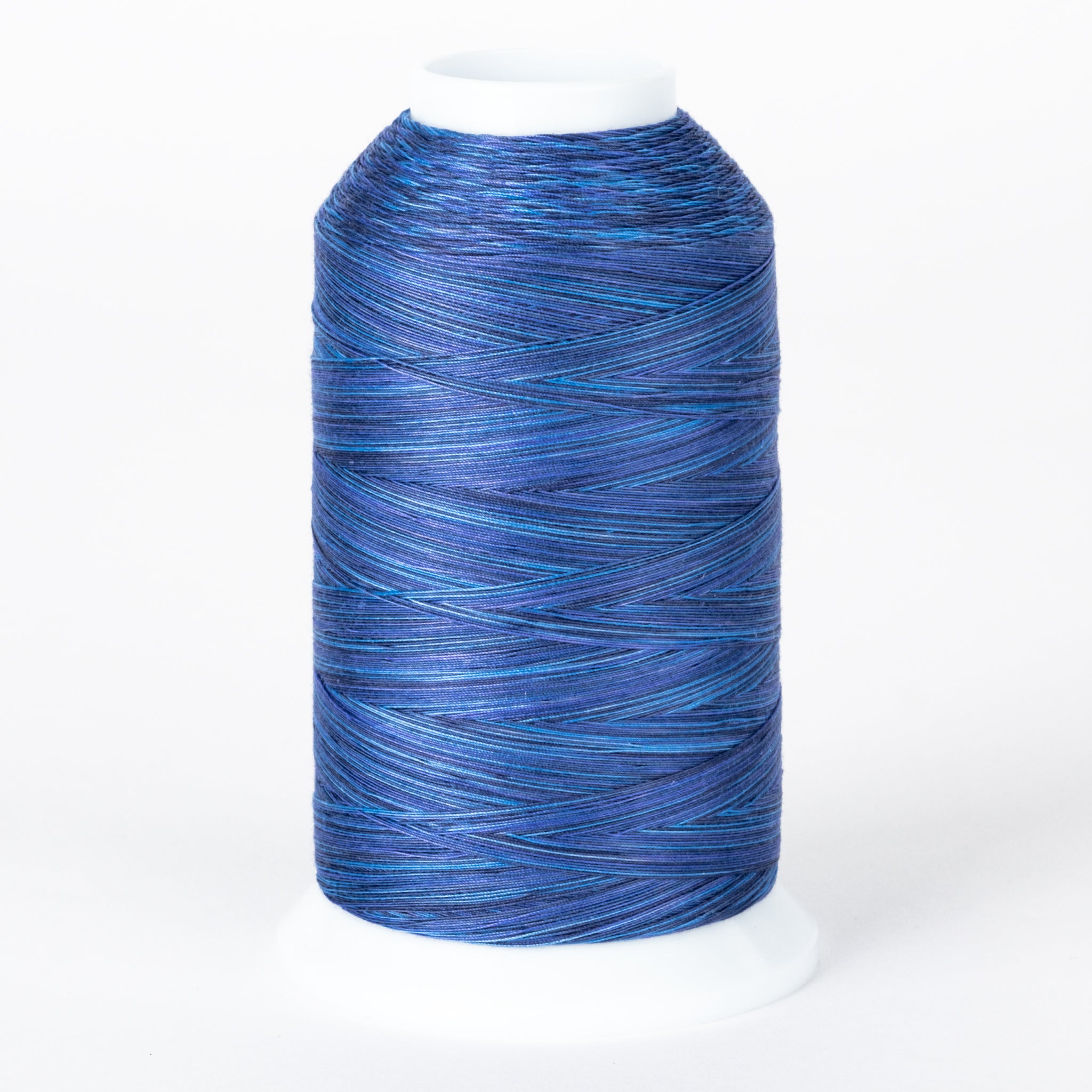 Blue variegated thread on white plastic cone with multiple shades of blue creating a marbled effect