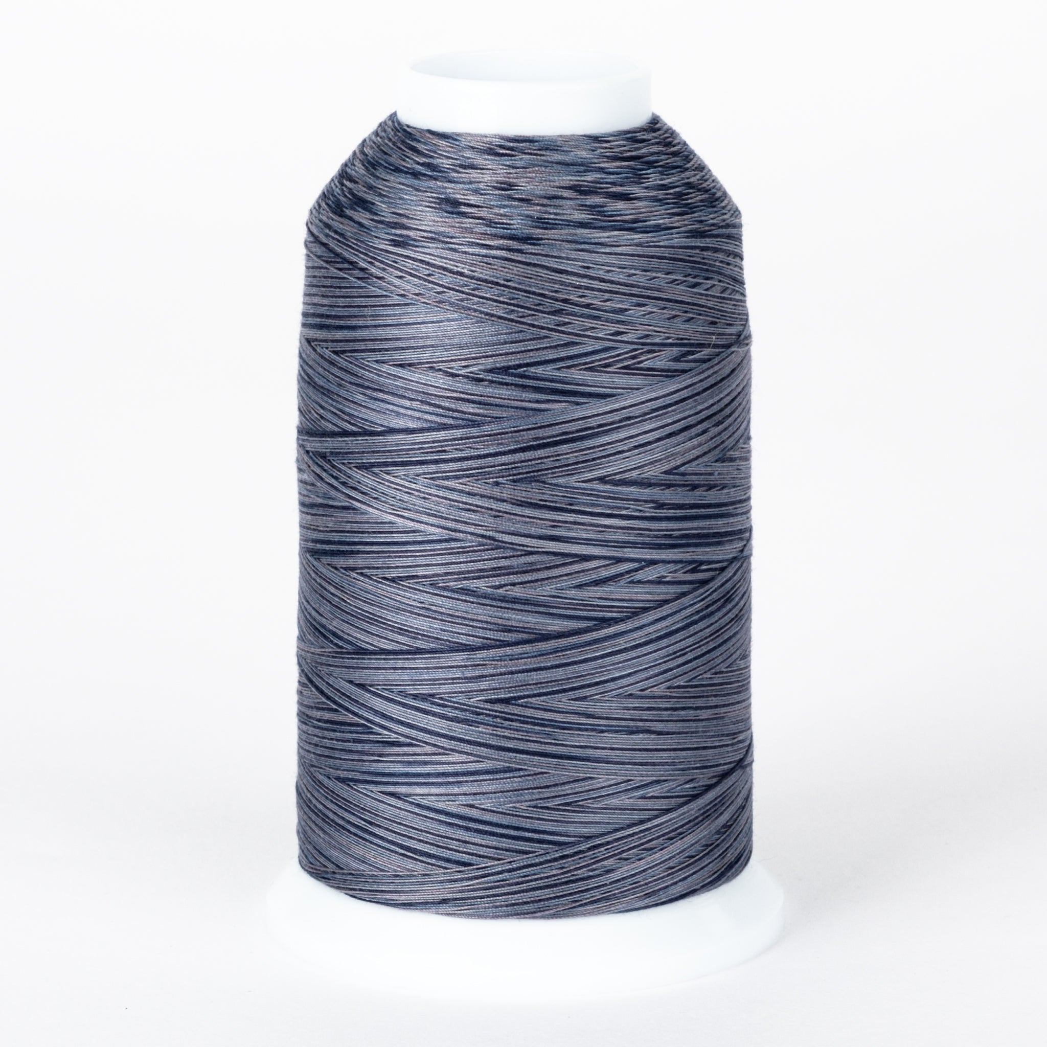 Nightfall variegated thread on white cone with dark blue, gray, and light blue multicolored strands wound in diagonal pattern