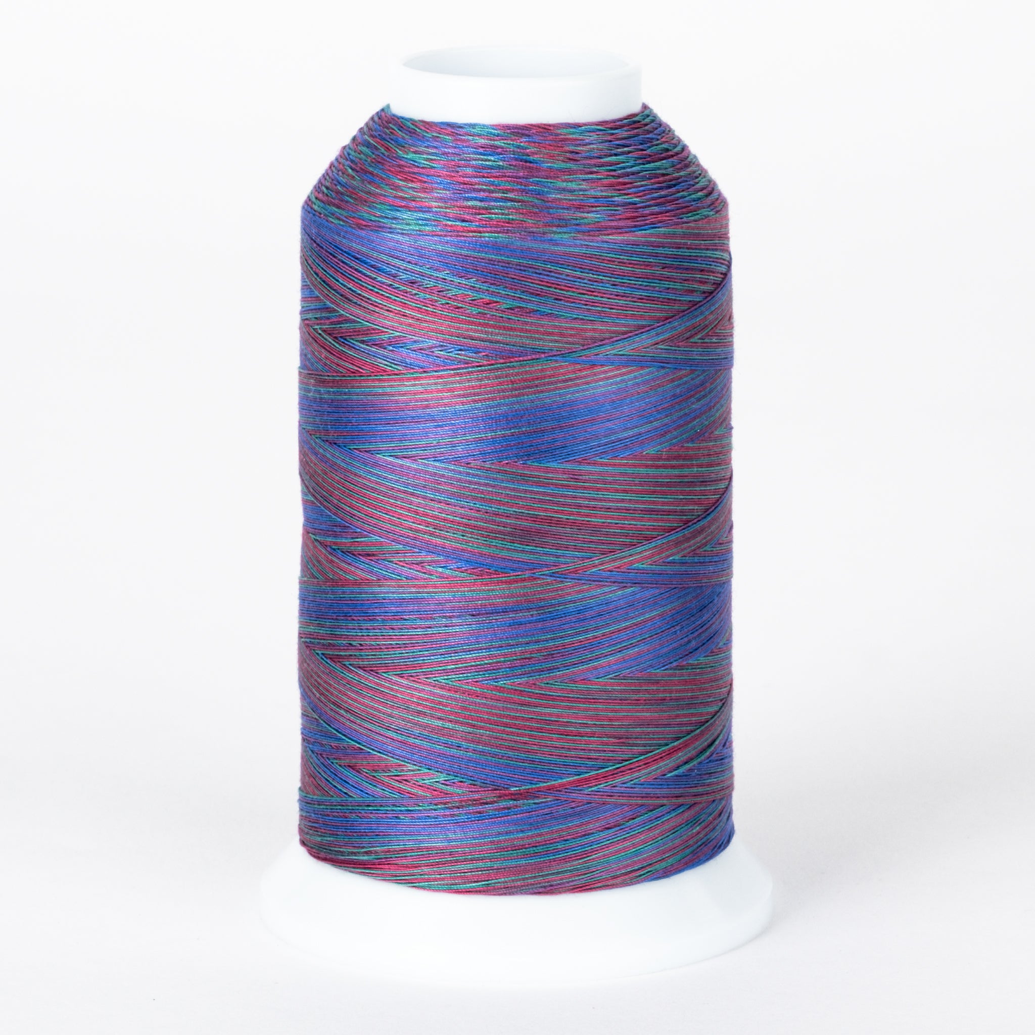 Multicolored variegated thread on white cone with blue, red, and purple strands creating a rainbow effect