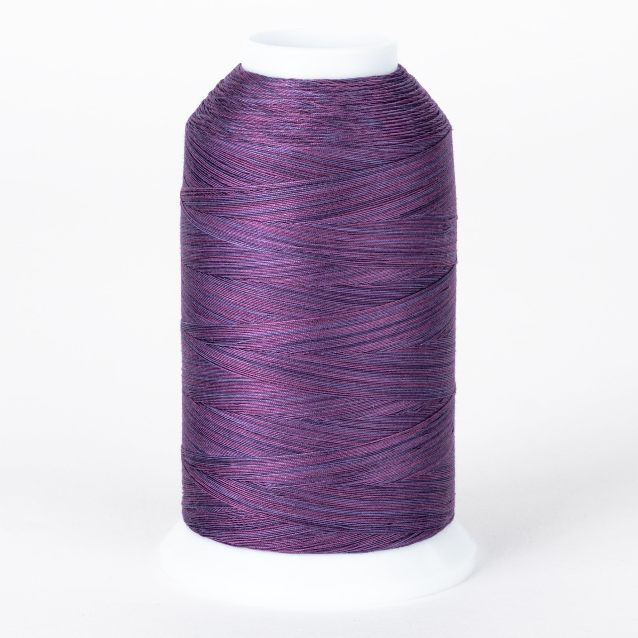 Purple variegated thread cone with heather tones, wound on white plastic cone with visible thread texture