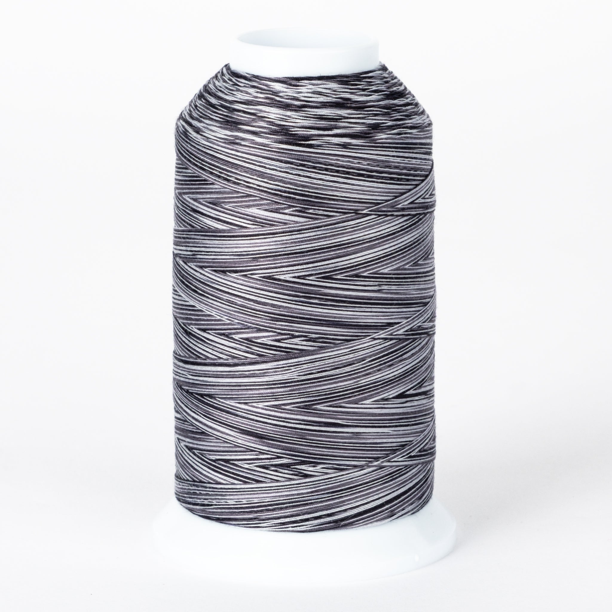 Zebra striped variegated thread on white plastic cone with black and white alternating pattern throughout