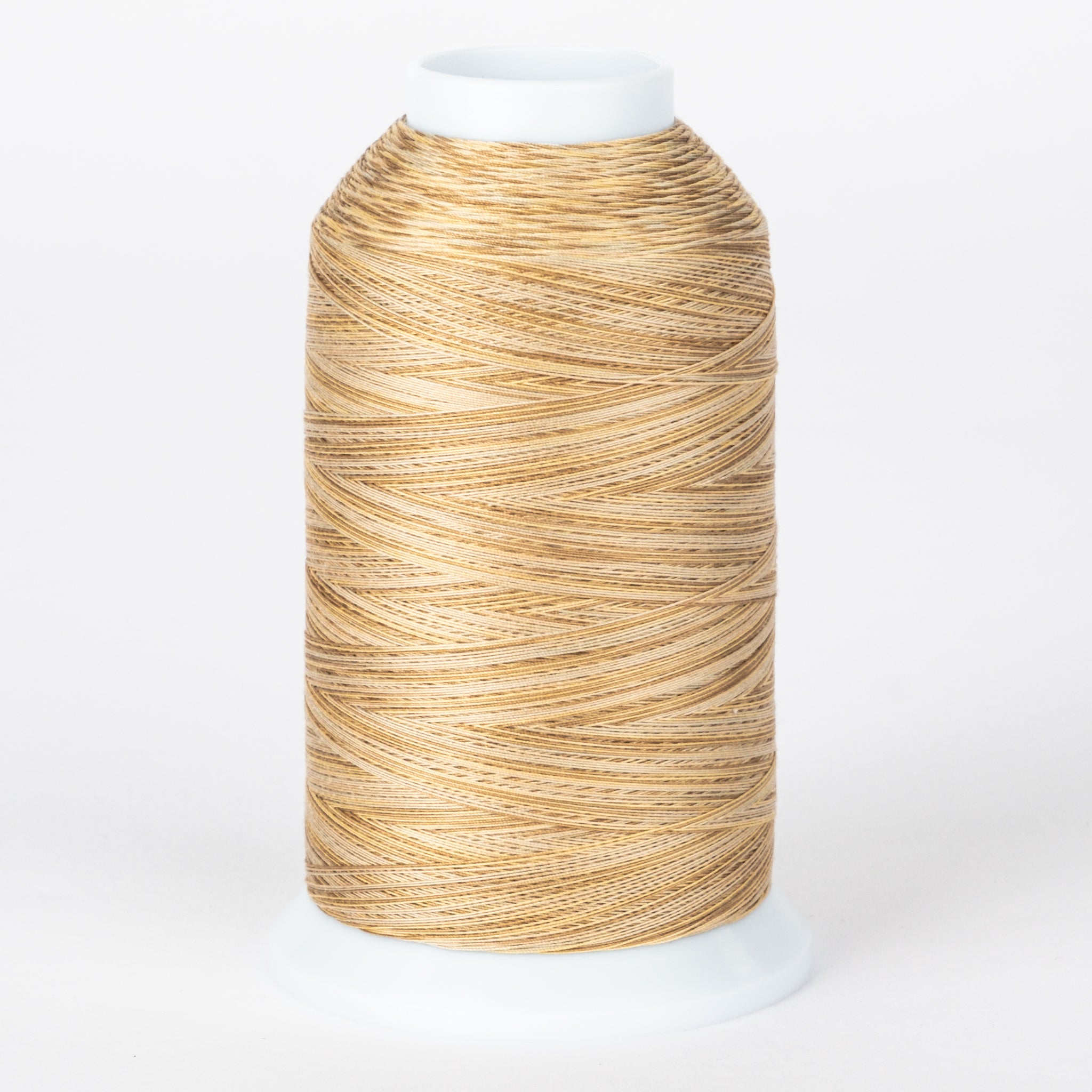 Tumbleweed variegated thread on white cone, showing golden brown and cream twisted strands