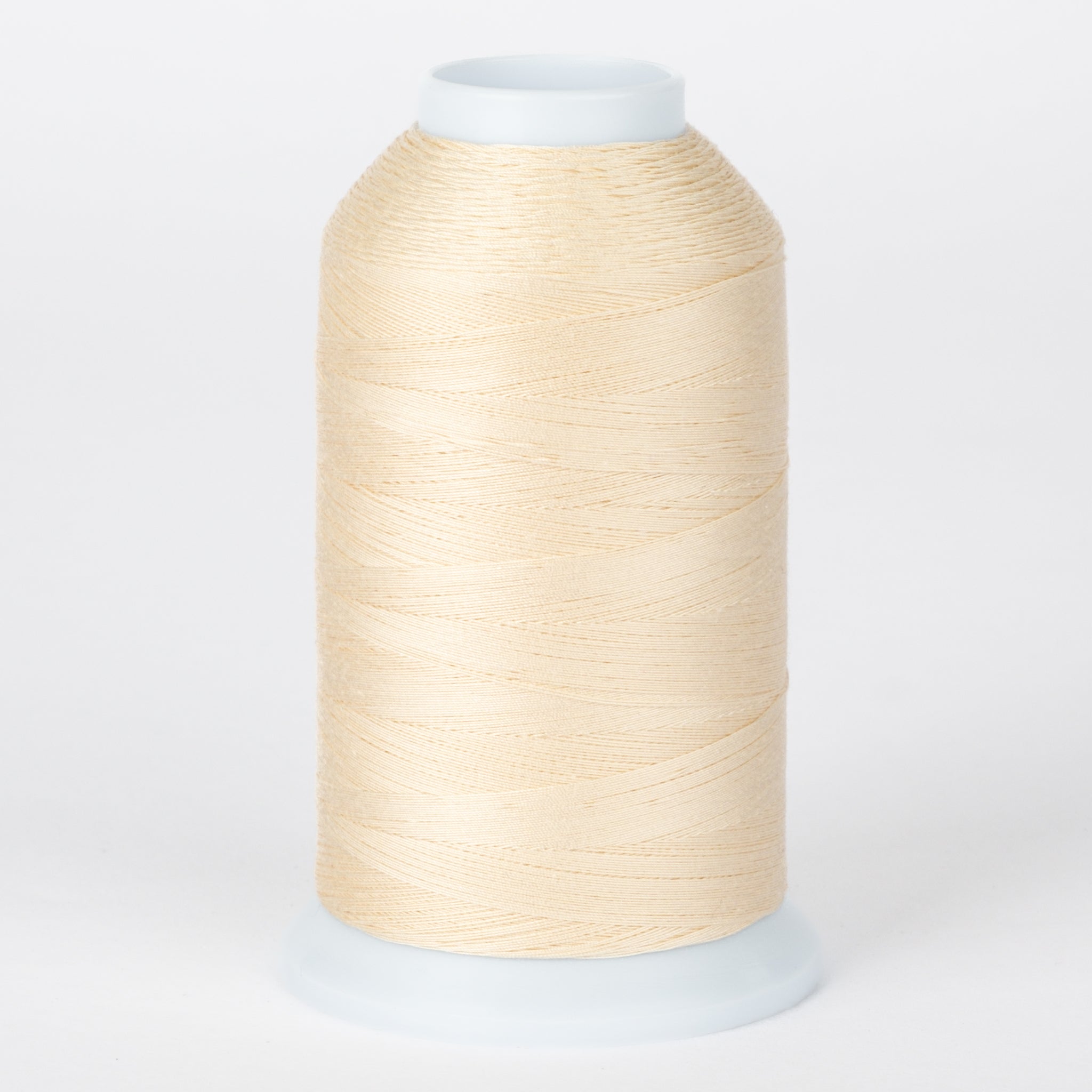 Antique cream thread wound on white plastic cone with clear cap
