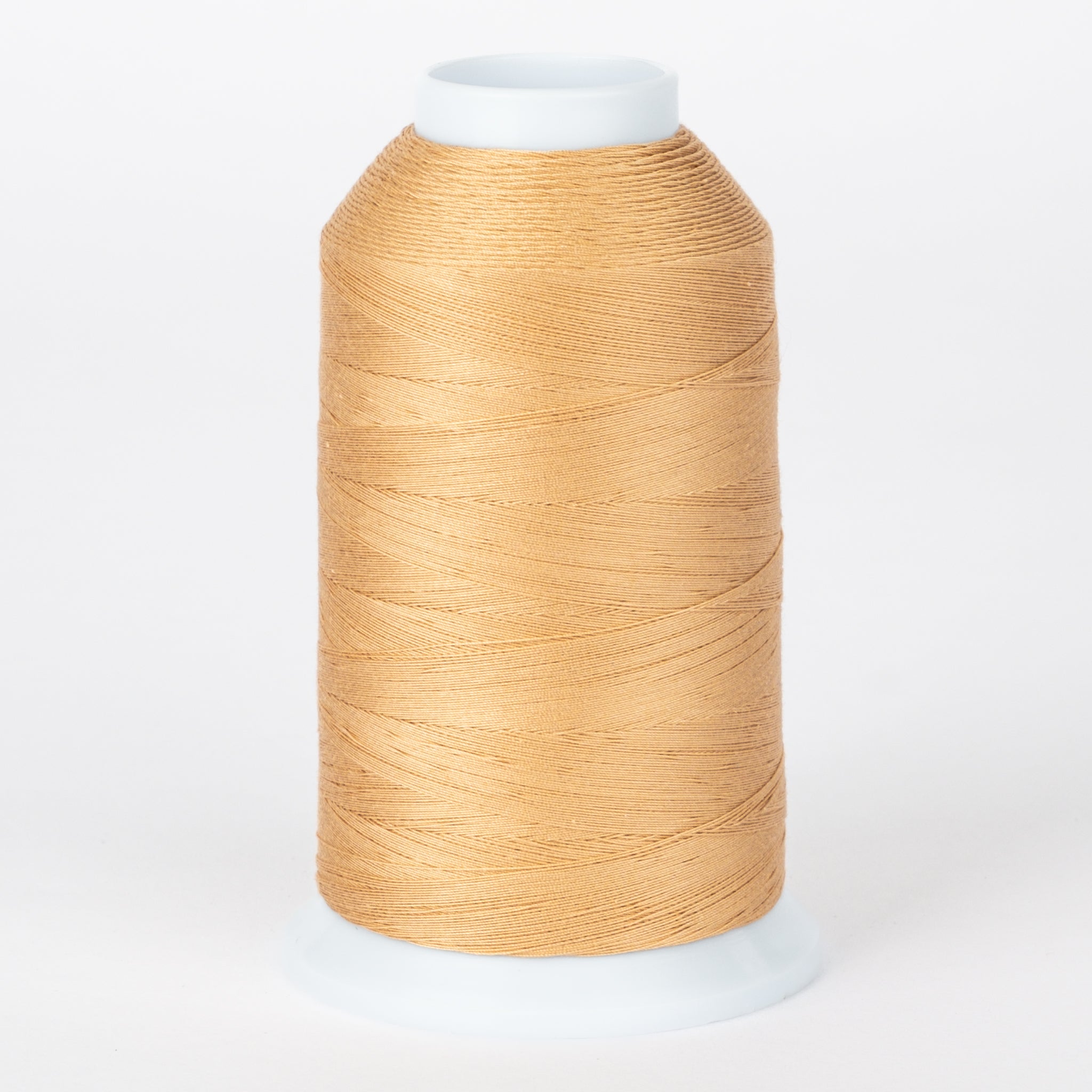 Almond colored thread wound on white plastic cone with clear protective cap