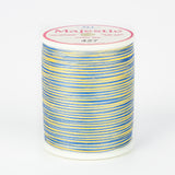 Multicolored blue and yellow variegated thread on white spool with Majestic brand label, color 427 Moonbeam