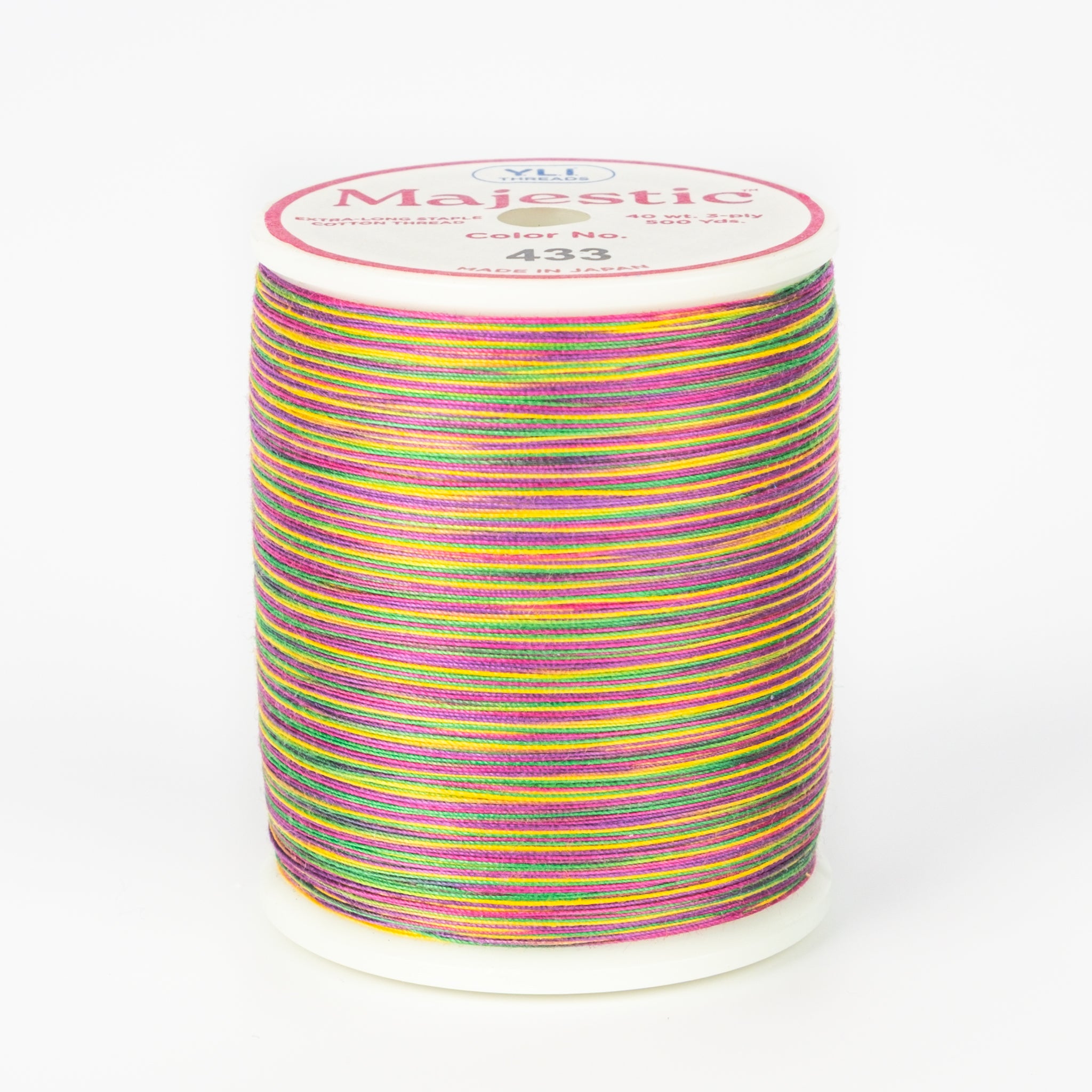 Multicolored variegated thread on white Majestic spool with bright rainbow stripes in pink, yellow, green, and purple.