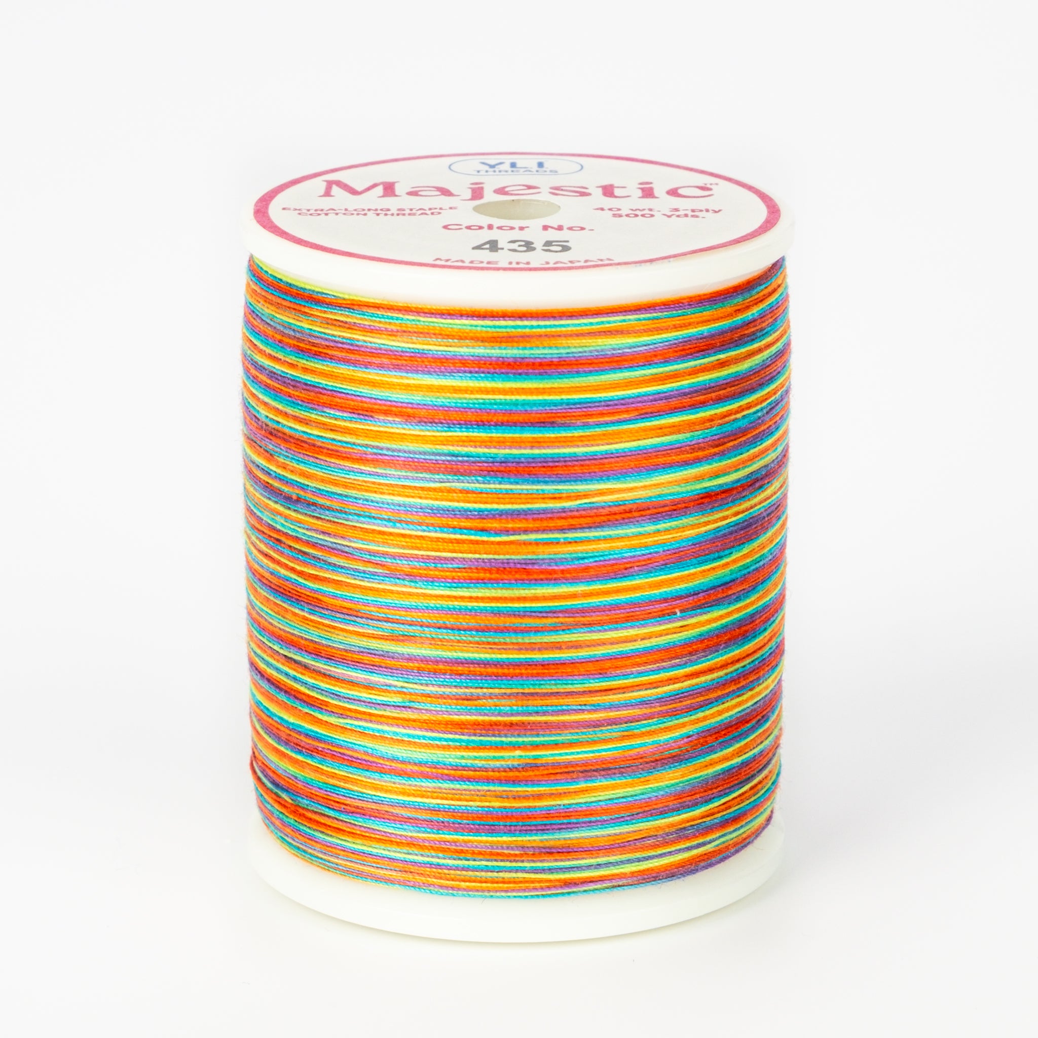 Multicolored variegated thread on white Majestic spool with bright rainbow stripes in orange, blue, pink, yellow