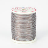 Variegated brown and gray Majestic thread on white plastic spool with pink and white label showing color number 436