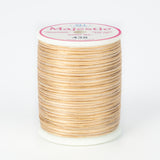Multicolored beige and brown variegated thread on white plastic spool with Majestic brand label, color 438 Tumbleweed