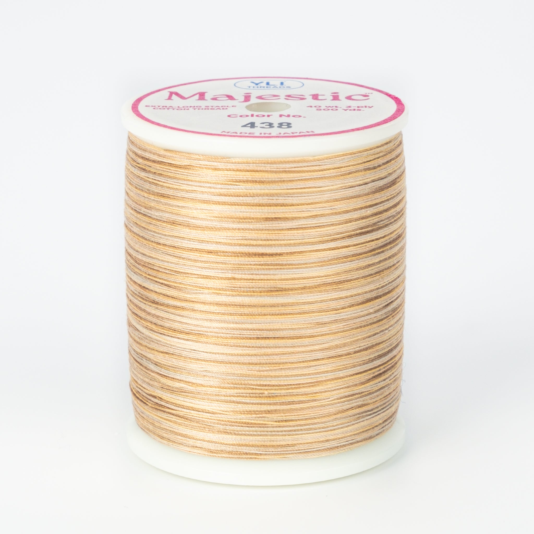 Multicolored beige and brown variegated thread on white plastic spool with Majestic brand label, color 438 Tumbleweed
