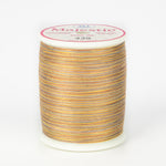 Variegated orange, yellow and gray thread on white spool with Majestic label, color 439 Walkabout