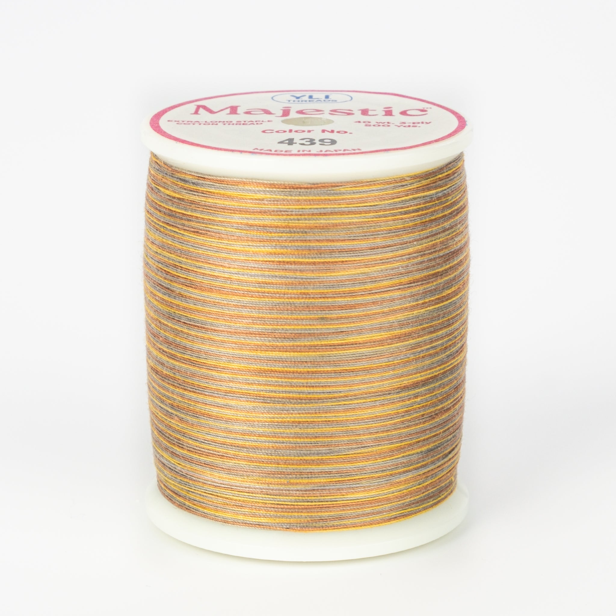 Variegated orange, yellow and gray thread on white spool with Majestic label, color 439 Walkabout