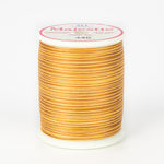 Orange and brown variegated Majestic thread on white spool with pink and white label showing color number 440