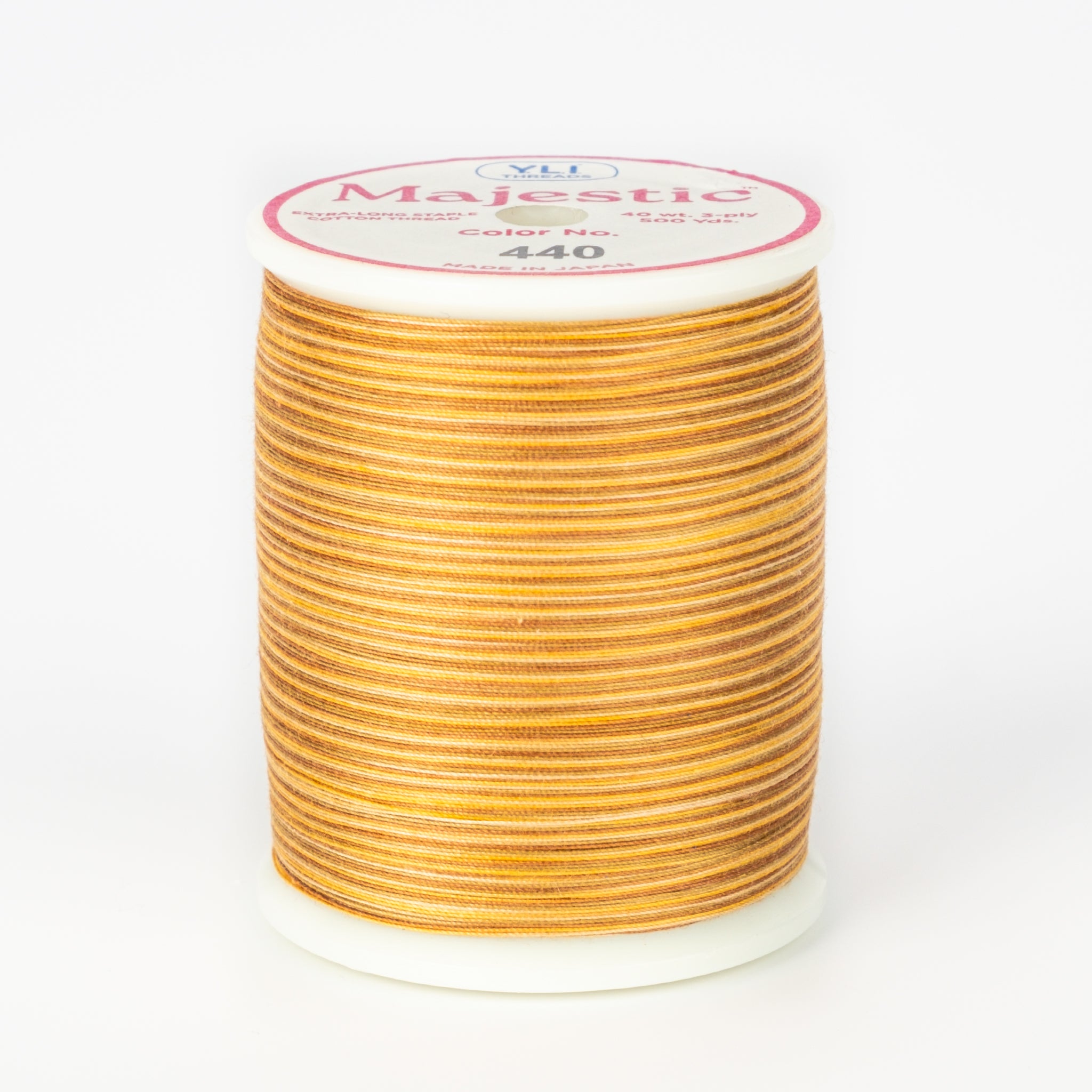 Orange and brown variegated Majestic thread on white spool with pink and white label showing color number 440