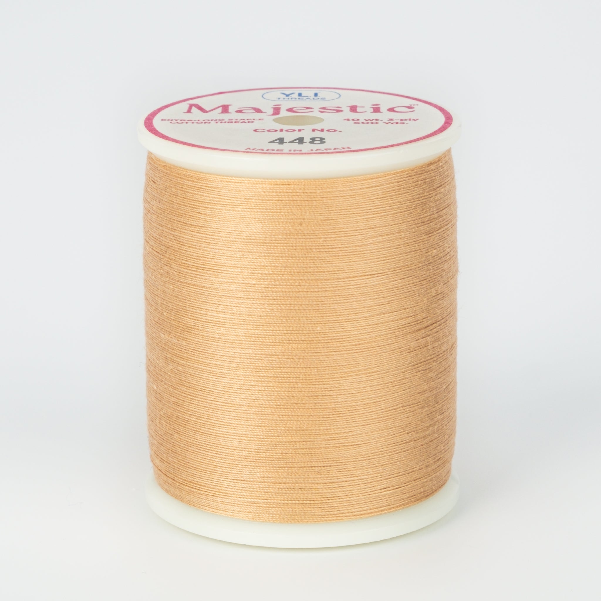 Almond colored thread wound on white plastic spool with Majestic brand label showing color number 448