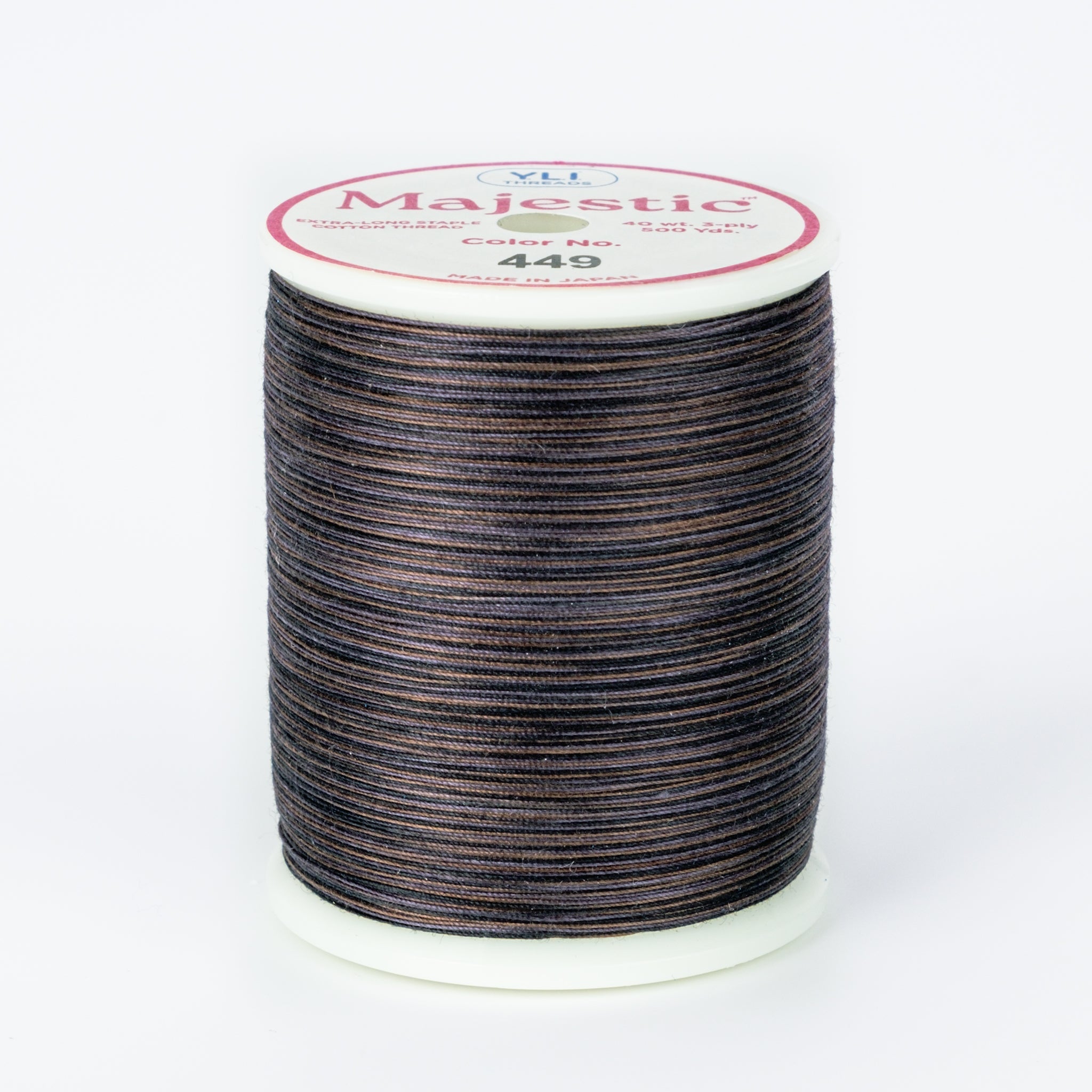 Dark variegated thread spool with navy, brown and gray tones on white plastic spool with Majestic label showing color 449