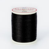 Black thread wound on white plastic spool with Majestic brand label, color number 450 visible on top