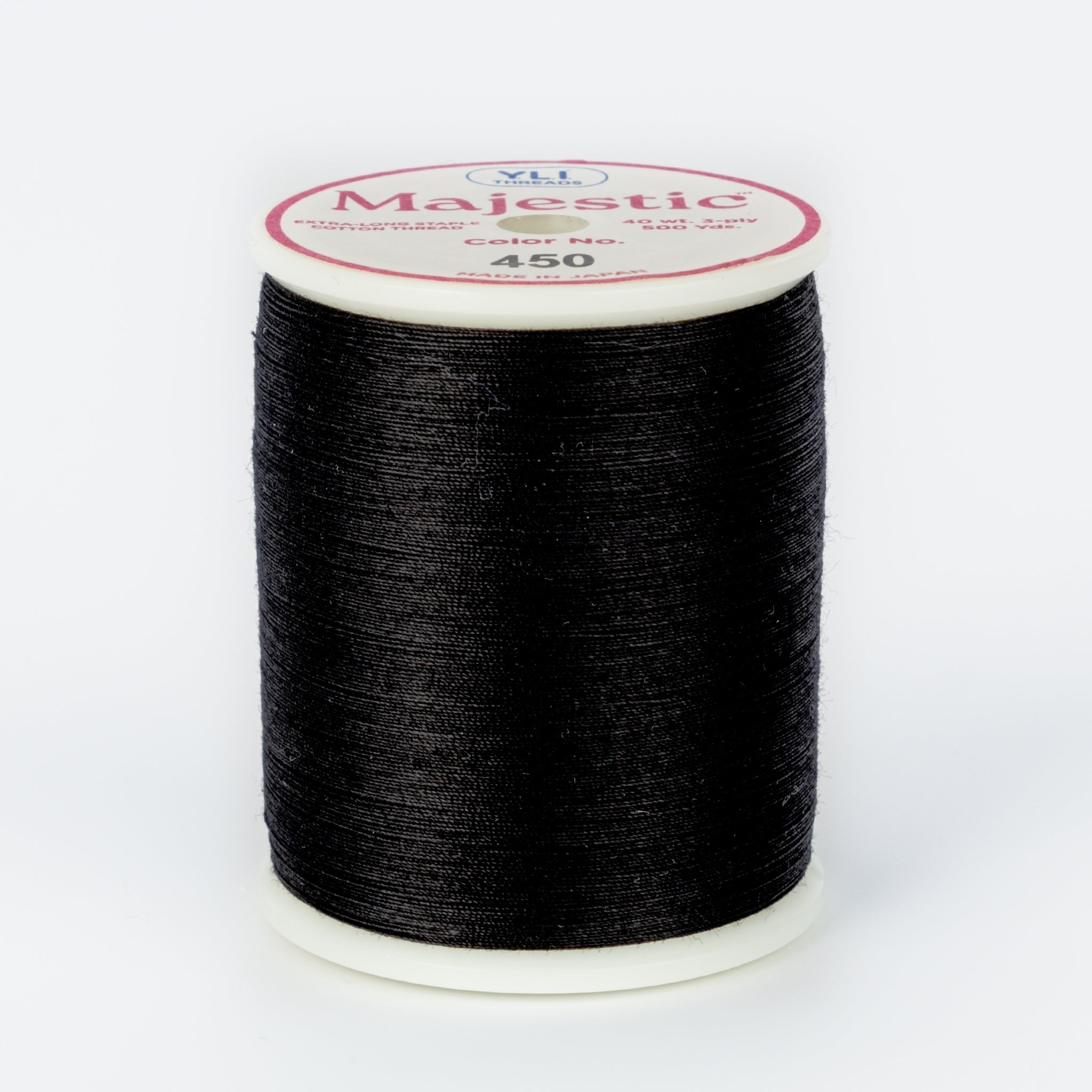 Black thread wound on white plastic spool with Majestic brand label, color number 450 visible on top