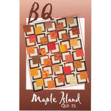 A quilt pattern featuring a geometric design with interlocking squares in warm autumn colors including orange, red, yellow, and brown fabrics.