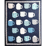 A quilted wall hanging featuring 16 coffee mug blocks in blue and white fabrics arranged in rows on a dark blue star-patterned background with white borders.
