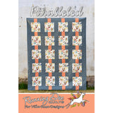 A quilt pattern showing a grid design with floral squares connected by coral-colored sashing strips on a blue-gray background.