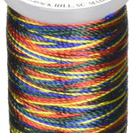Multicolored variegated rayon thread on white mini cone spool with dark red, blue, yellow, and green stripes.