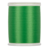 Green sewing thread wound on white plastic spool with clear top and bottom caps
