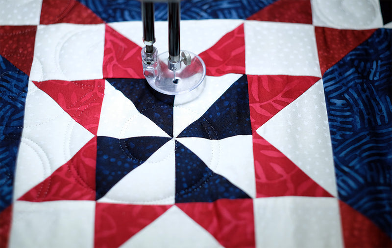 close up photo of quilting on a longarm machine with invisible thread