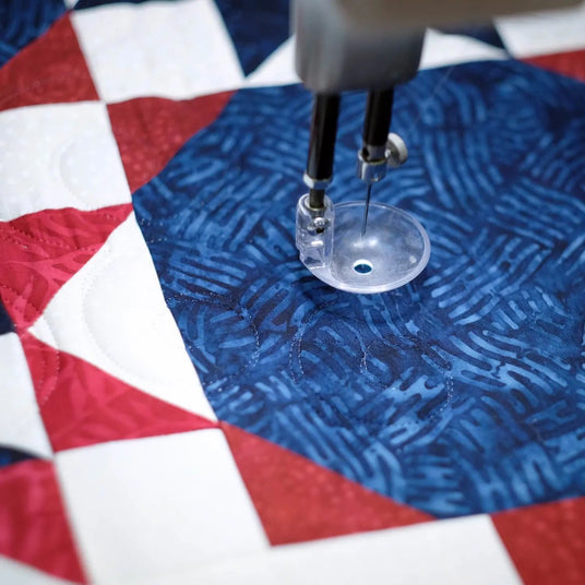 close up of a longarm quilting needle on a quilt