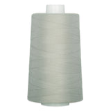 Light sage green thread wound on a white plastic cone spool