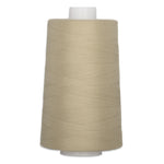 Fawn colored thread wound on white plastic cone spool