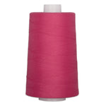 Large cone of dragonfruit pink quilting thread on white spool for sewing and quilting projects.