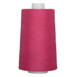 Large cone of dragonfruit pink quilting thread on white spool for sewing and quilting projects.